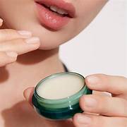 Applying La Mer luxury lip treatment to lips